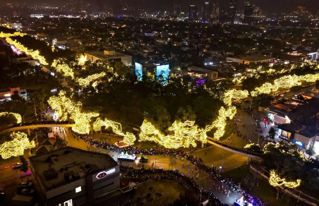 Vista aérea nocturna de Monterrey con iluminación navideña monumental sobre el parque