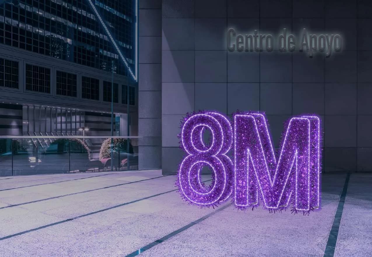 Letras gigantes '8M' en luz púrpura